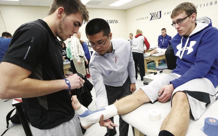 students assisting another's foot injury